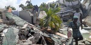 Pessoas caminham entre escombros de casas destruídas pelo terremoto em Les Cayes, no Haiti — Foto: Jose Flecher/cortesia via Reuters